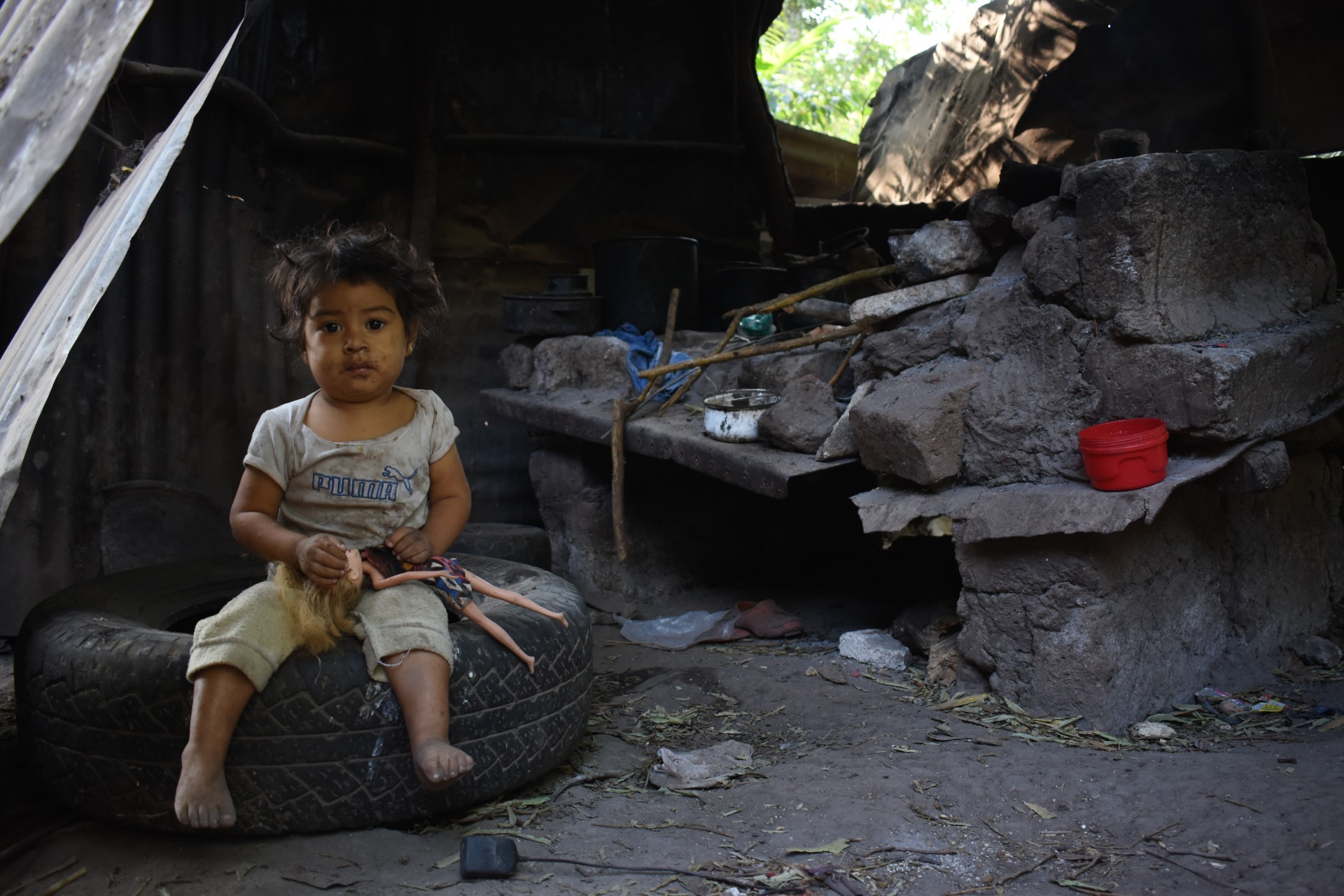 Retrato de Samanta, a un costado del comal de leña en donde su mamá prepara los alimentos para la familia. Aldea La Carrete, Nueva Santa Rosa.